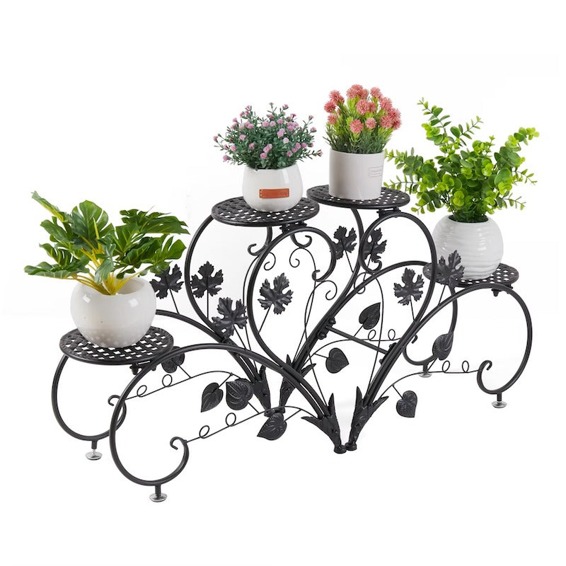 Decorative metal plant stand with potted plants on a white background