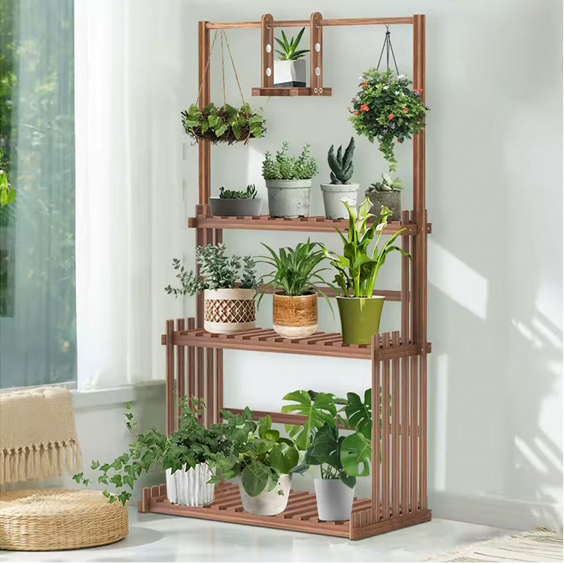 A tall wooden plant stand with four tiers and hanging hooks, styled with an assortment of potted houseplants in a bright, modern room.