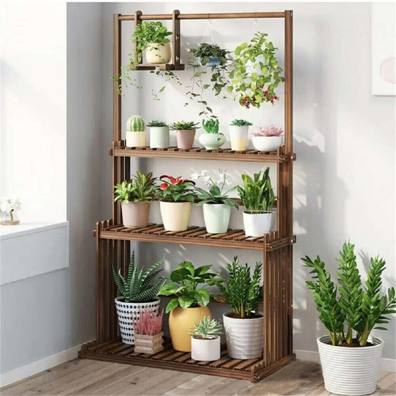 Wooden plant stand with various potted plants against a white wall.