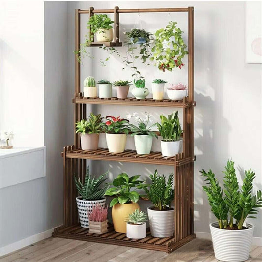 Wooden plant stand with various potted plants against a white wall.