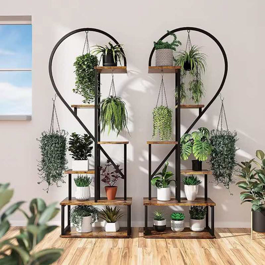 Two black metal shelving units with plants on a wooden floor.