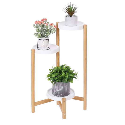 3 tiered plant stand with a natural bamboo frame and three round white shelves, each holding a small potted plant against a white background.